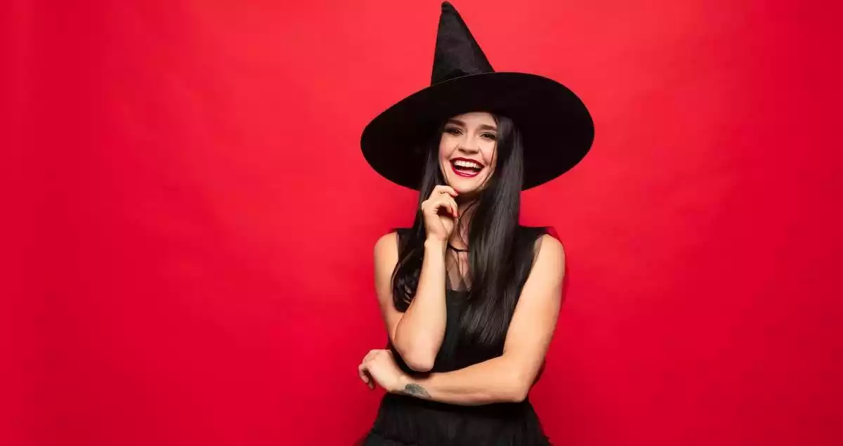 A smiling woman dressed up as a witch